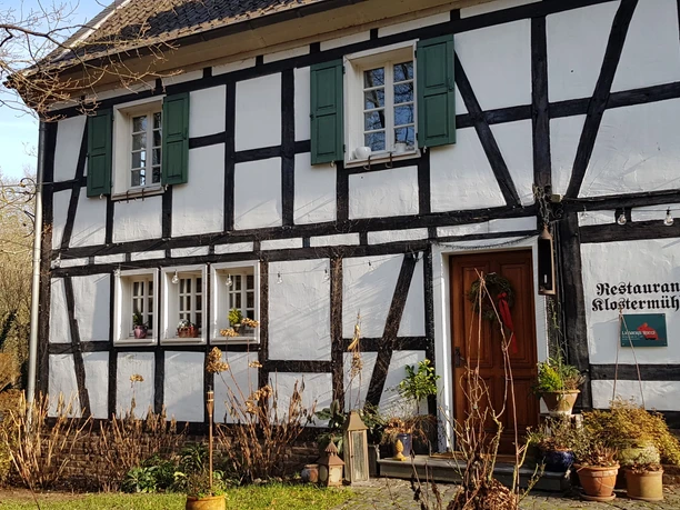 Rösrather Vielfalt: Klostermühle Rösrath Die historische Klostermühle Rösrath, ein Fachwerkhaus mit grünen Fensterläden, beherbergt ein Restaurant.