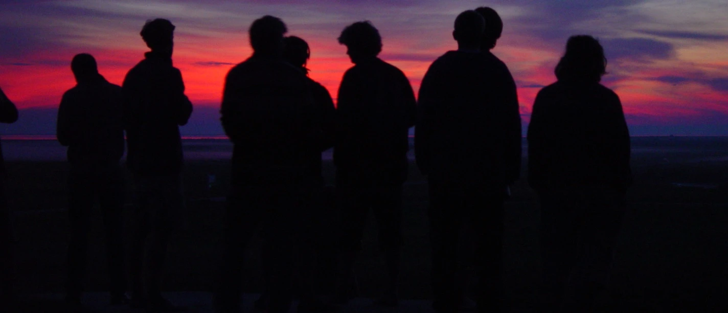 Abendwanderung am Deich Personen stehen vor schönem Himmel der Abenddämmerung