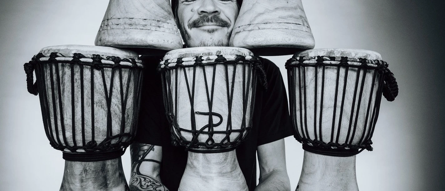 Trommelrabatz in Büsum Ein Schwarzweißbild von einem Mann zwischen Trommeln.
