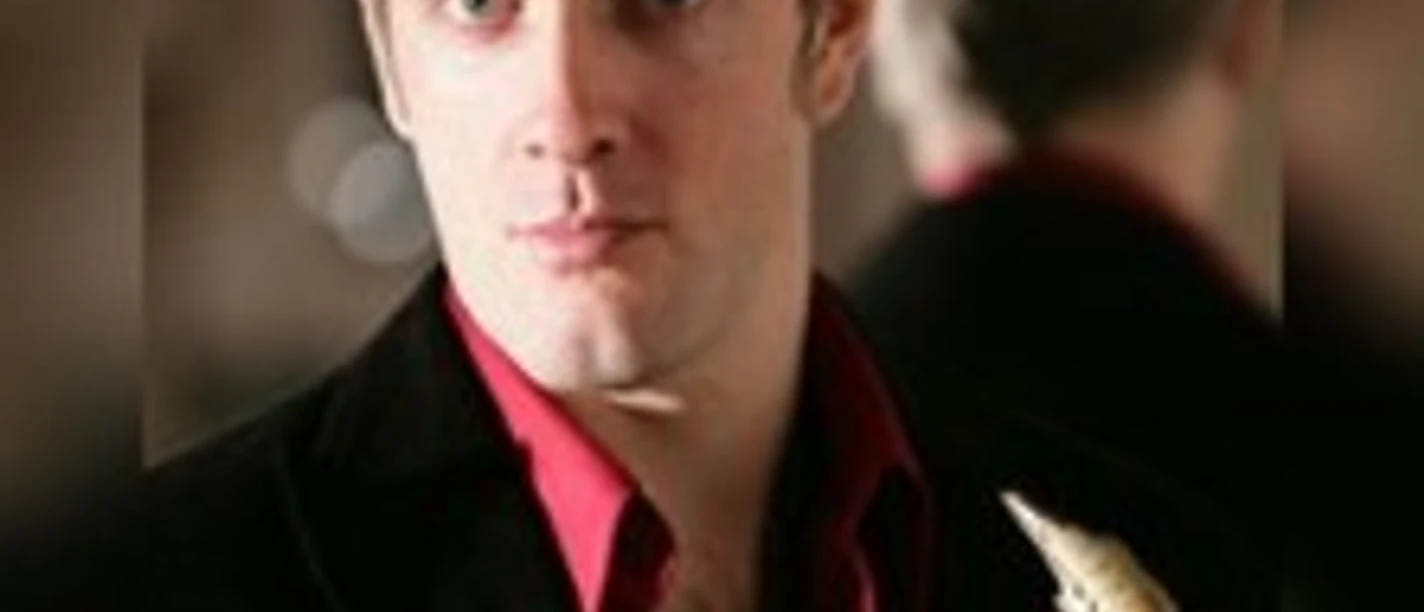 Porträt eines Mannes mit Saxophon in festlicher Kleidung vor weichem Hintergrund.