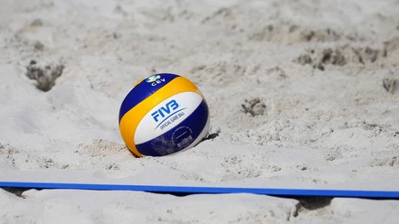 Beachvolleyball (c) Pixabay.jpg Ein Beachvolleyball liegt im Sand neben der Feld-Linie.
