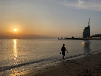 Spazieren bei Sonnenuntergang_Weser-Strandbad_Seelust_Panorama IMG_3916 (c)Rieke Nagel_Erlebnis Bremerhaven.jpg Frau spaziert am Weser-Strandbad in Bremerhaven bei Sonnenuntergang.