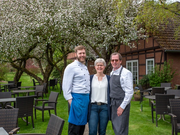 Bilder Thomas, Hilke, Janis von Karo Biermann Familie Rund bestehend aus dem Sohn, links, der Mutter in der Mitte und dem Vater, rechts in ihrem Garten des Landgasthauses.
