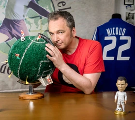 Arnd Zeigler mit Fußball-Globus und Miniaturen, dahinter Trikot mit Nummer 22