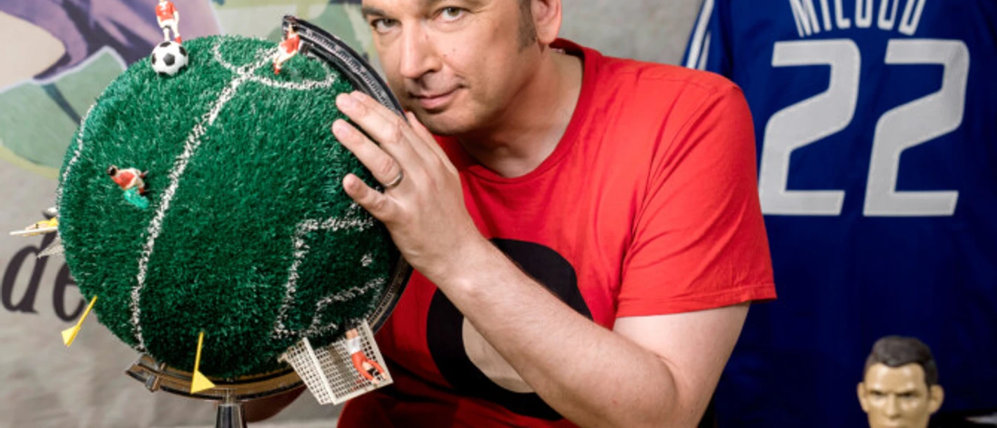 Arnd Zeigler Arnd Zeigler mit Fußball-Globus und Miniaturen, dahinter Trikot mit Nummer 22