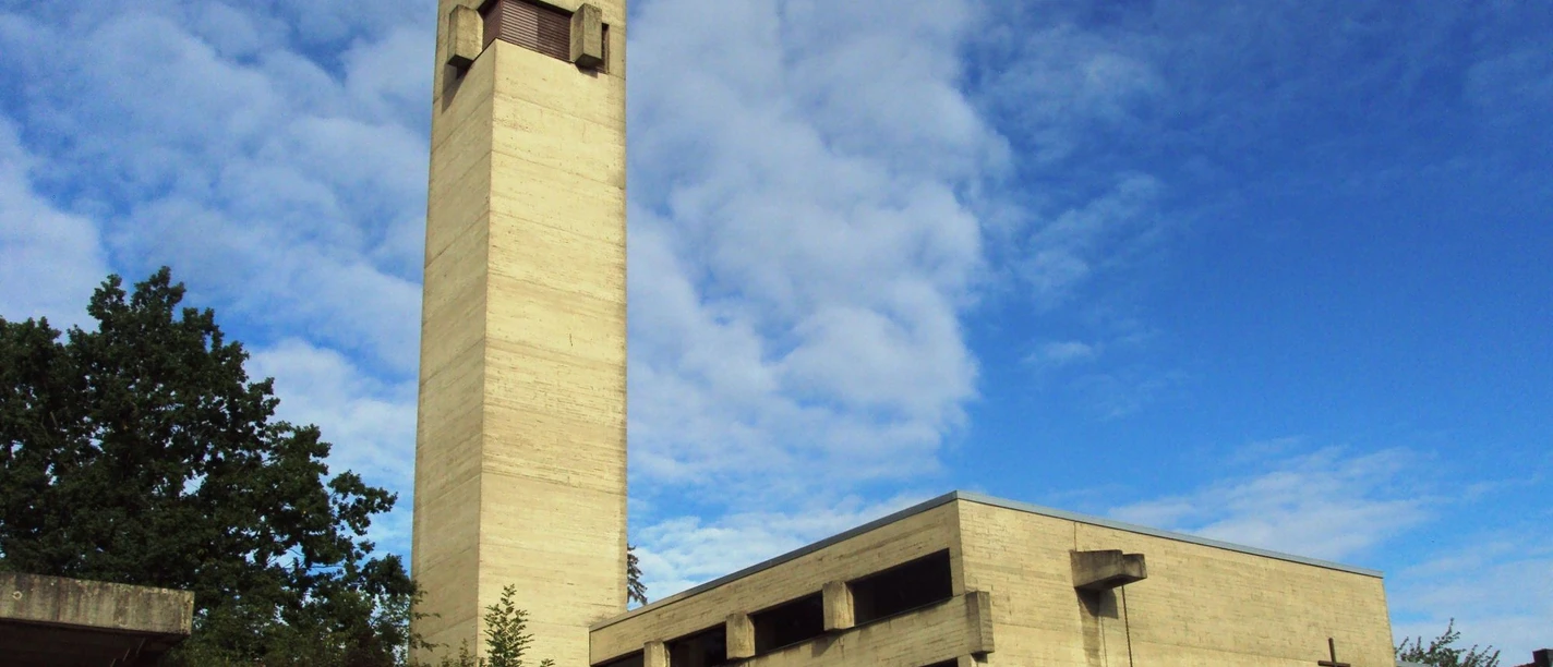 Martin-Luther-Kirche_Salzgitter-Bad_HD_16zu9.JPG Betonfassade der Martin-Luther-Kirche mit markantem Turm unter blauem Himmel.