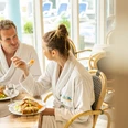 Driburg-Therme-Bistro Paar im Bademantel genießt Salat und warme Speisen im Bistro der Driburg Therme.