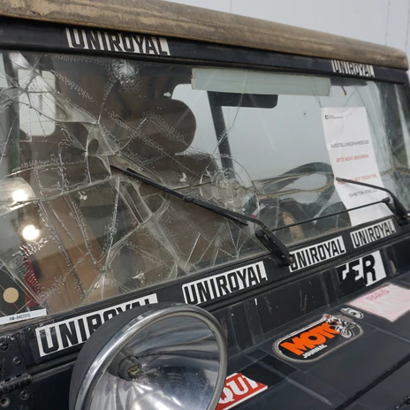 Automuseum - Rallye-Wagen - Scheibe.JPG Eine kaputte Windschutzscheibe eines alten Rallye-Autos im Museum. Es sind Aufkleber zu sehen.