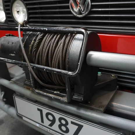 Automuseum - Winde.JPG Frontpartie eines roten VW-Fahrzeugs mit montierter Seilwinde am grauen Stoßfänger.