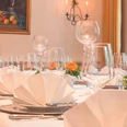 Gedeckter Tisch - Der Schwallenhof Festlich gedeckter Tisch mit weißen Servietten, Weingläsern und Rosen.