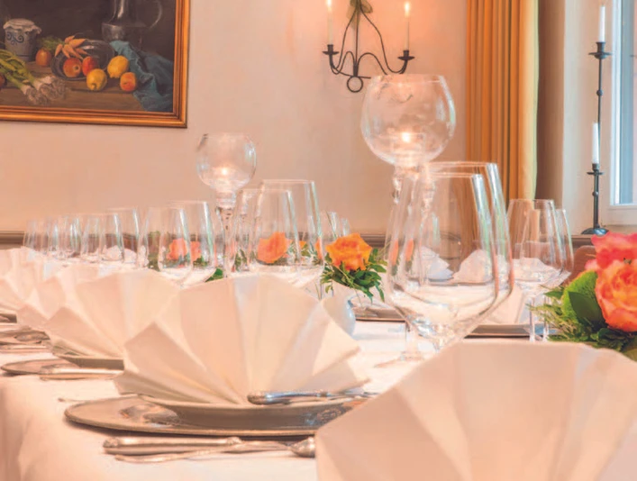 Gedeckter Tisch - Der Schwallenhof Festlich gedeckter Tisch mit weißen Servietten, Weingläsern und Rosen.