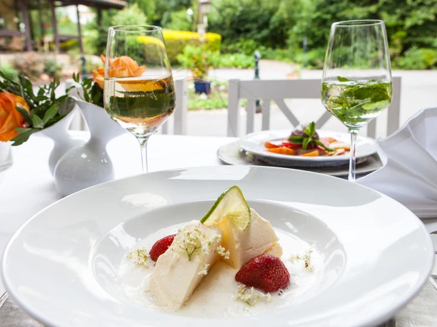 Nachtisch im Schwallenhof Dessertteller auf weiß gedecktem Terrassentisch.