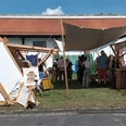 2023_Mittelaltermarkt Gebhardshagen (3)_HD_16zu9.jpg Weiße Leinen-Zelte und Besucher auf dem Mittelaltermarkt an der Wasserburg Gebhardshagen.