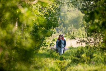 MoorIZ Ahlenmoor Wanderer spazieren durch die sonnendurchflutete Naturlandschaft des Ahlenmoors.