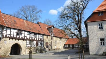 Wasserburg(44)_HD_16zu9.JPG Blick in den Innenhof der Wasserburg Gebhardshagen mit Fachwerkfassade, Steinmauern und Torbogen.