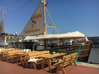 Eiscafé Zuckerkutter im Neuen Hafen mit Tischen und Bänken auf der Kaje davor