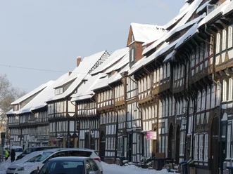 Tiedexer Straße, Winter Verschneite historische Fachwerkzeile der Tiedexer Straße in Einbeck unter blauem Himmel.