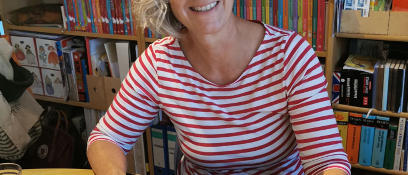 Alice Pantermüller "Mein Lotta-Leben" Autorin Alice Pantermüller lächelt am Schreibtisch vor Bücherregal