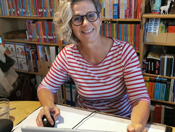 Alice Pantermüller "Mein Lotta-Leben" Autorin Alice Pantermüller lächelt am Schreibtisch vor Bücherregal