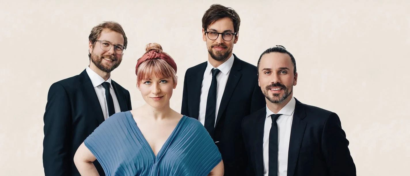 Grammophon Jazzband Die vier Mitglieder der Grammophon Jazzband in eleganter Kleidung vor hellem Hintergrund.