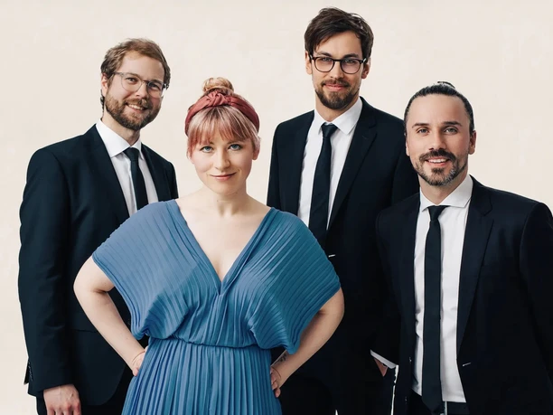 Grammophon Jazzband Die vier Mitglieder der Grammophon Jazzband in eleganter Kleidung vor hellem Hintergrund.