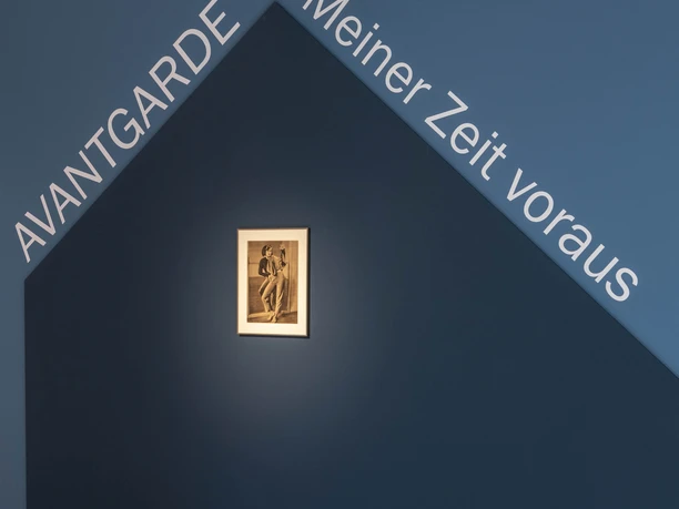 Dance Museum of the German Dance Archive Cologne Exhibition room with blue wall design, dance photo and large face motif on the floor.