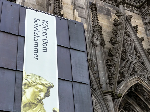 Cathedral Treasury Banner for the Cologne Cathedral Treasury in front of the richly decorated Gothic façade