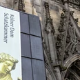 Domschatzkammer Banner zur Kölner Domschatzkammer vor der reich verzierten gotischen Außenfassade