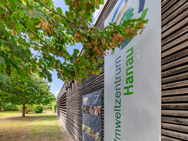 RheinMain Hanau Umweltzentrum Schild Umweltzentrum Hanau an Holzfassade im Grünen