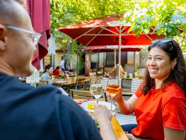 RheinMain Offenbach - Trattodino Gäste stoßen mit Wein in der Außengastronomie des Trattodino in Offenbach am Main an