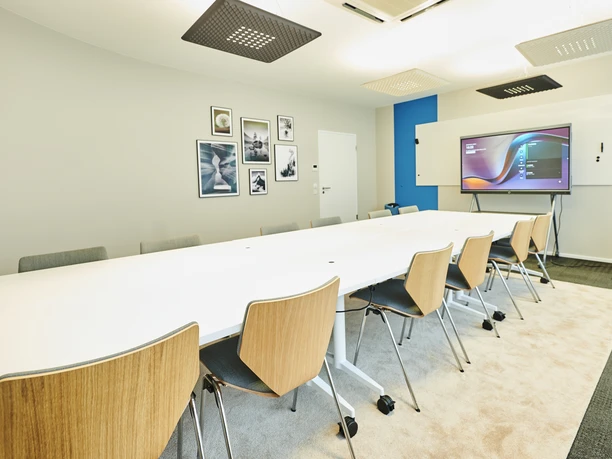 Breakout Room - weitläufiger Konferenzraum weitläufiger Konferenzraum mit Reihenbestuhlung aus Holzstühlen.