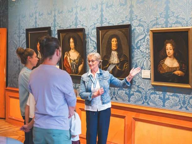 Gästeführung vor historischen Porträts im Celler Schloss