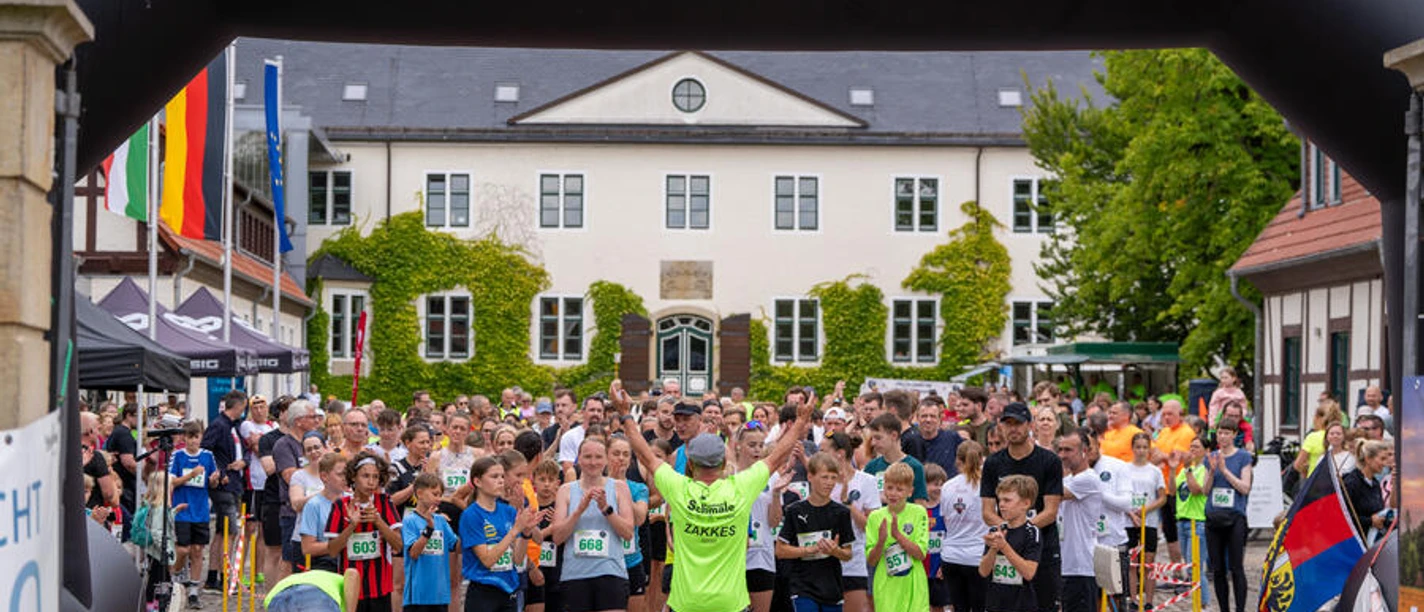 Benkhauser Schlosslauf Start des Benkhauser Schlosslaufs vor Schloss Benkhausen mit Läuferfeld unter Startbogen
