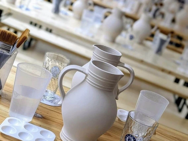Unpainted Bembel jug on table with brushes in studio