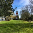 aboutcities_Bremerhaven_Leuchtturm(c) Dörte Behrmann_WEB.jpg Rot-weiß gestreifter Leuchtturm Brinkamahof umgeben von Grün