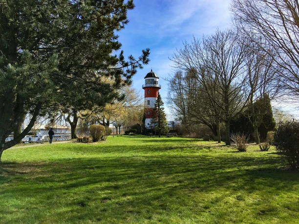 aboutcities_Bremerhaven_Leuchtturm(c) Dörte Behrmann_WEB.jpg Rot-weiß gestreifter Leuchtturm Brinkamahof umgeben von Grün