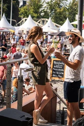 Gourmet Festival am Schokoladenmuseum in Köln Zwei Personen stoßen mit Getränken an, umgeben von Festivalständen und Publikum.