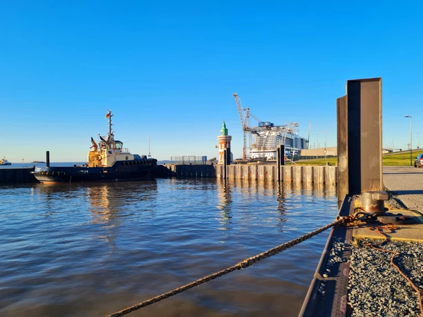20211220_142511 (c) Dagmar Brandenburg_Erlebnis Bremerhaven_WEB.jpg Blick übers Wasser zum Pingelturm, Schlepper und Kreuzfahrtschiff