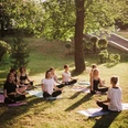 Group of women practice meditate in city park on summer sunny morning Group of women practice meditate in city park on summer sunny morning