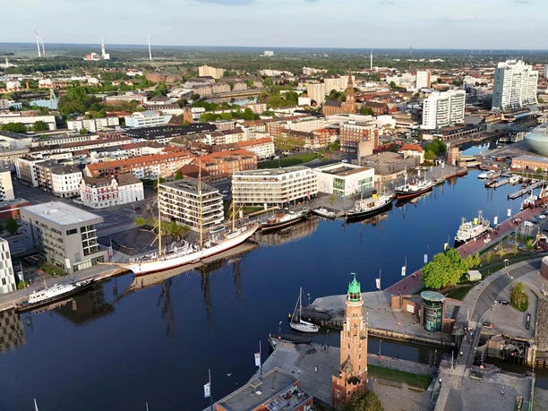 1.5.25Stadtmitte13 (c) Alexander Scheer_Erlebnis Bremerhaven_WEB.jpg Luftbild vom Neuen Hafen mit Schiffen und Gebäuden in Bremerhaven
