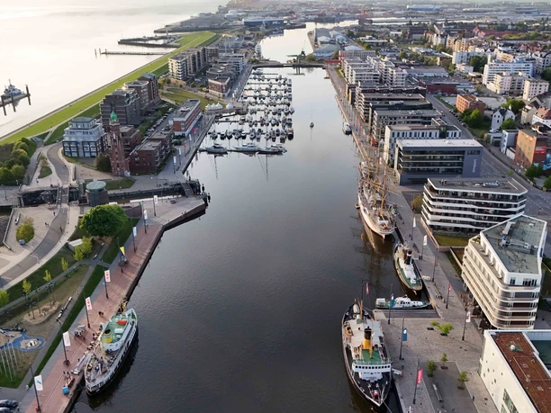 1.5.25Stadtmitte10 (c) Alexander Scheer_Erlebnis Bremerhaven_WEB.jpg Luftaufnahme Neuer Hafen Bremerhaven, Deich und Weser