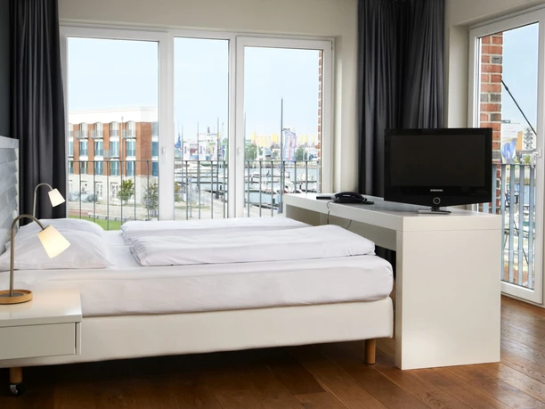 MICE Kapitäns-Suite_1016 (c) im-jaich_WEB.jpg Blick vom Schlafzimmer aus dem im Jaich-Hotelzimmer hinaus auf die Marina mit Sport- und Segelbooten