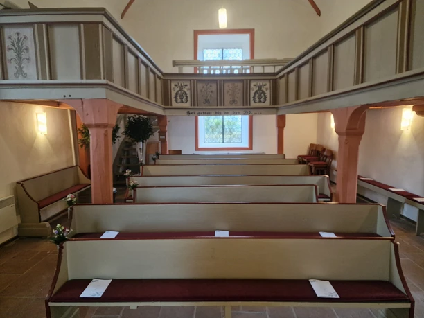 Innenansicht, Bänke & Empore Sie sehen den Blick vom Altar in das Kirchenschiff, mit den Sitzbänken und der umlaufenden Empore.