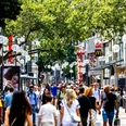 Schildergasse Busy shopping street with lots of passers-by, stores and shade from large trees