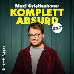 Mann vor grünem Vorhang mit gelber Aufschrift Komplett AbsurD und Comedy-Hinweis