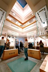 Kant-Museum Besucher betrachten helle Vitrinen im Kant-Museum mit großen Begriffen wie Raum und Zeit.