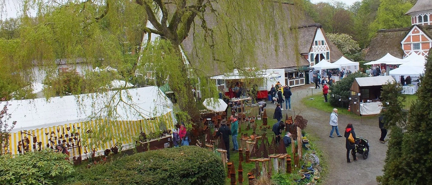 Kunsthandwerkermarkt Taubenhof Marktstände und Besucher im grünen Außenbereich des historischen Taubenhof Cadenberge.