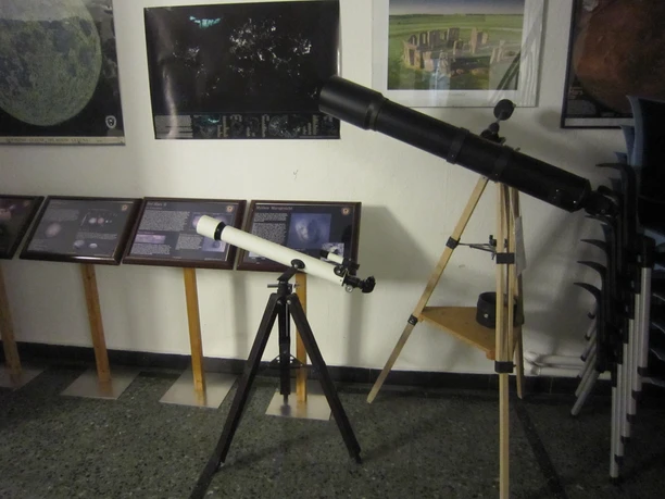 IMG_5688_Planetarium_(c)Tanja Albert_Erlebnis Bremerhaven.JPG Zwei Teleskope auf Stativen stehen vor Infotafeln und Postern zu Astronomiethemen im Raum.