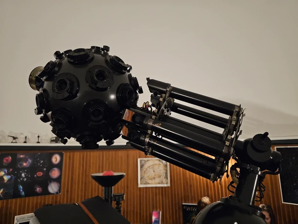 20241111_155610 (c) Tanja Mehl_Erlebnis Bremerhaven.jpg Großer, schwarzer Sternprojektor im Planetarium Bremerhaven vor holzvertäfelten Wänden.