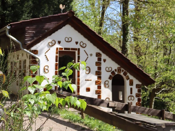 Osterzeit im Märchenwald Knusperhäuschen im Märchenwald Altenberg, dekoriert mit Brezeln und kleinen Ziegeln.